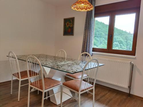 Rombach-le-Franc圣鲁丹度假屋的一间带桌椅和窗户的用餐室