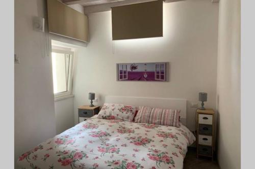 波尔莱扎Casetta al Portico, relax e tranquillità的一间卧室配有一张带花卉床罩的床