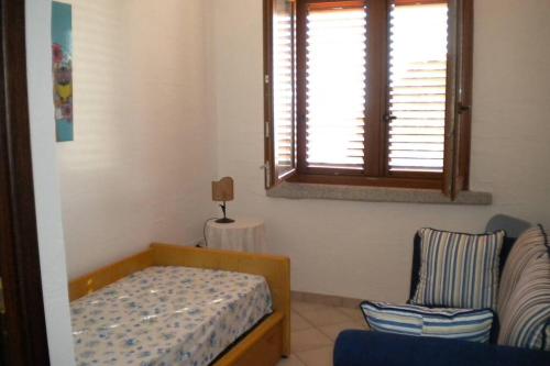 内比达Villa sul mare panorama unico的一间卧室设有一张床、一个窗口和一把椅子
