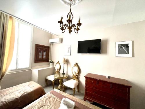戛纳Hotel le Romanesque的一间卧室配有一张床、梳妆台和电视。