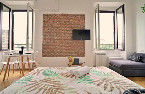 米兰P&D Apartments Darsena的一间卧室设有一张床和砖墙