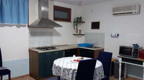 奇尼斯Appartamentino Cinisi的厨房配有一张桌子,上面有白色的桌布