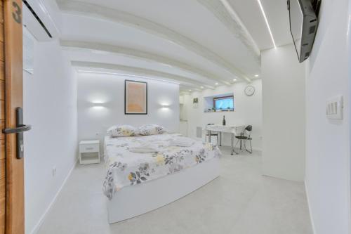 普拉Apartment light in Pula的白色的客房配有一张床和一张桌子