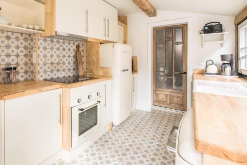 达默Tilia的厨房配有白色家电,铺有瓷砖地板。