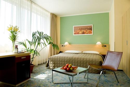 布拉格迈克酒店的酒店客房,配有床和一张带水果的桌子