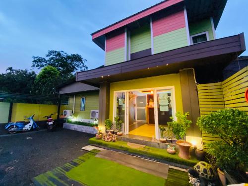 攀牙帕科尔精品度假酒店的一座色彩缤纷的房子,前面有草坪