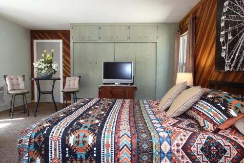克恩维尔Kern Riverview Inn的一间卧室配有一张床和一台平面电视