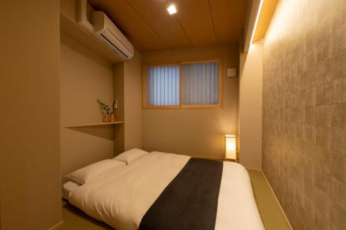 大阪Shirakabanoyado - EBISU的一间小卧室,配有床和窗户