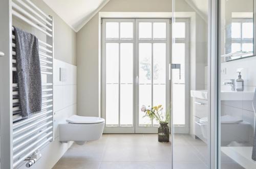 普雷罗ReetTraum Prerow的白色的浴室设有卫生间和玻璃门