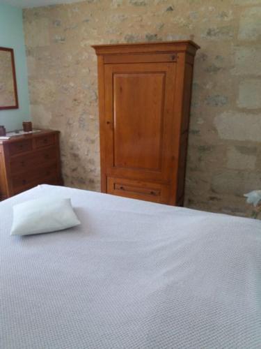 TeuillacGîte 6 personnes Les Gîtes du Chardon的卧室配有白色的床和木制橱柜。