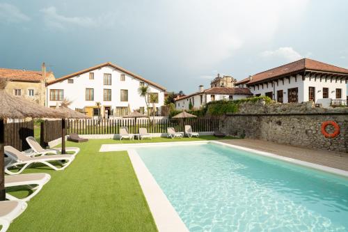 Villaverde de PontonesJardines Villaverde的一个带椅子的游泳池以及一座房子
