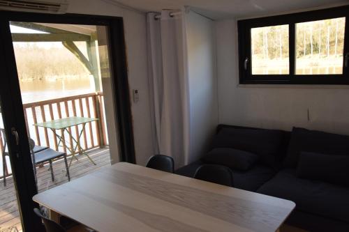 Panzoultbateau du moulin girault的带沙发和桌子的客厅以及阳台。