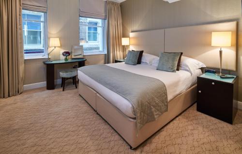 伦敦仕骅廷圣保罗大教堂酒店公寓的酒店客房设有一张大床和一张书桌。