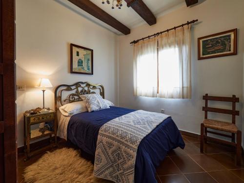 库迪列罗Finca Engracia的一间卧室配有一张带蓝色毯子的床和窗户。