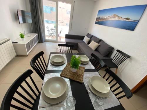 布拉内斯Apartamentos AR Isern的客厅配有餐桌和椅子