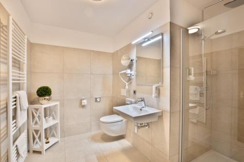 吕伯克Deeke's Quellenhof的浴室配有卫生间、盥洗盆和淋浴。