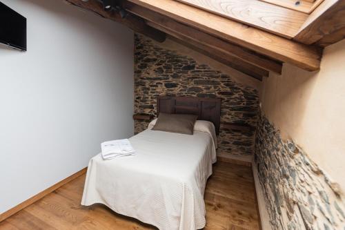 CoañaApartamentos Rurales Casa Llongo的一间小卧室,卧室内有一张砖墙床