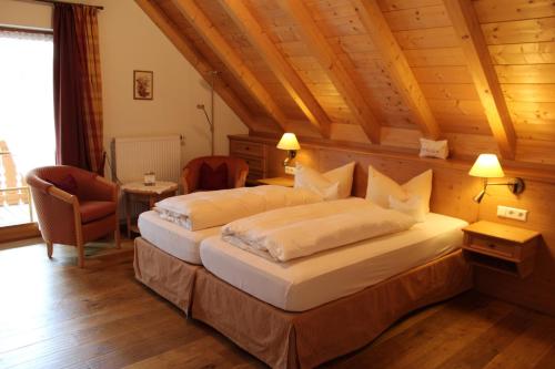 黑林山区贝尔瑙Naturparkhotel Schwarzwaldhaus的一间带两张床的卧室,位于木天花板的房间