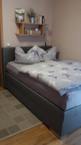 BornichMarktstübchen, Einzelzimmer的一张铺有白色床单和紫色花卉的床