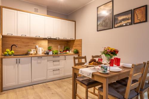 下乌斯奇基Apartament Słoneczny Poranek的厨房以及带桌椅的用餐室。