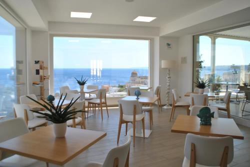 圣凯撒利亚温泉Est hotel的餐厅设有桌椅和大窗户。