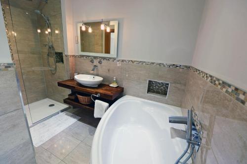 桑德斯富特Priory Cottage - Luxury Cottage, Near to Beach的带浴缸和盥洗盆的浴室