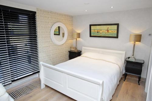 海边的艾格蒙特Aan Zee en Duin的卧室配有白色的床和镜子