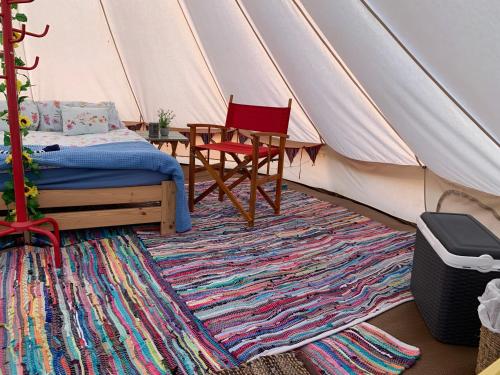 约克Freespirit Glamping的一间卧室配有带一张床和椅子的帐篷