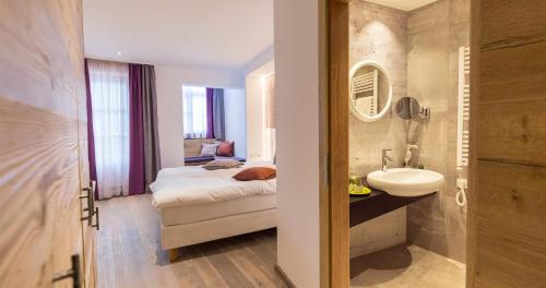 弗拉绍Hotel Flachauerhof的客房内的浴室设有床和水槽