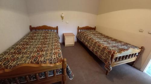 迪利然DILI Cottage的两张睡床彼此相邻,位于一个房间里