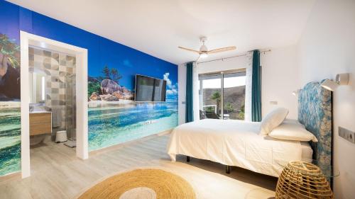 PájaraEtti Paradise - Suite Oceano的一间卧室配有一张床,墙上配有电视