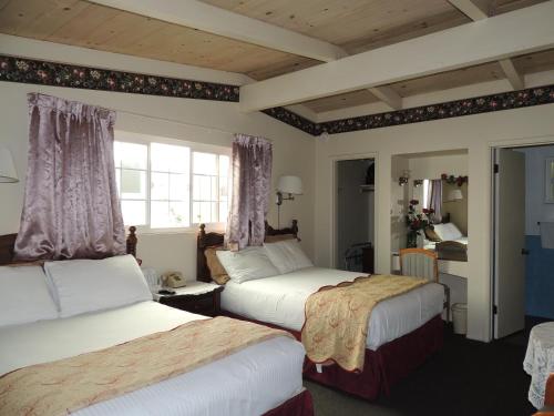 莫罗贝莫罗贝日落汽车旅馆的一间卧室设有两张床和窗户。