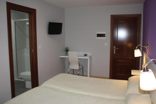 格拉纳达Verona的一间卧室配有一张床、一个卫生间和一张书桌