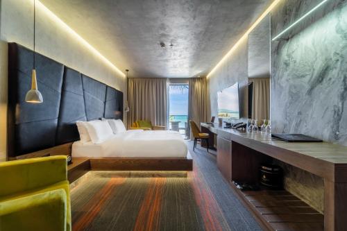 格勒姆Pinea Hotel Resort & Spa的配有一张床和一张书桌的酒店客房