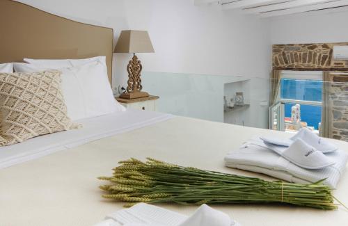 埃尔莫波利斯TOP SUITES的一张带毛巾和绿色洋葱的白色床