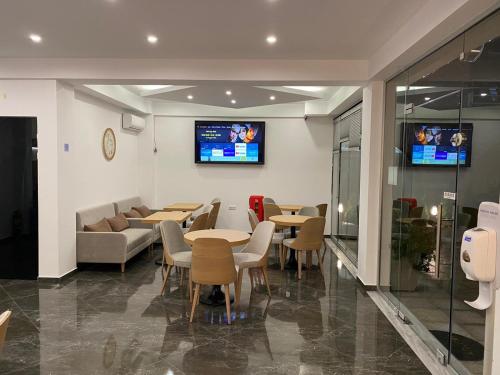 普利瑙港湾Hotel Medusa的一间带桌椅的餐厅以及墙上的电视