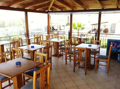 拉加纳斯安德里奥拉海滩酒店的一间空餐厅,配有木桌和椅子