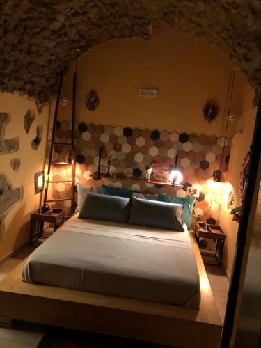 那不勒斯Donna Margherita Appartamento的一间卧室设有一张带石墙的大床