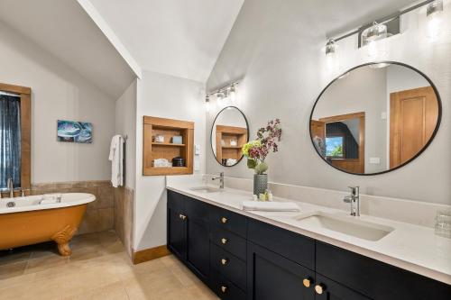 兰里Saratoga Inn的浴室配有2个盥洗盆、浴缸和大镜子