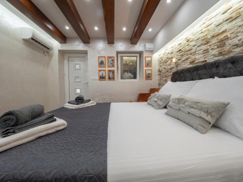 布德瓦Luxury Boutique Studio的卧室配有白色大床和砖墙