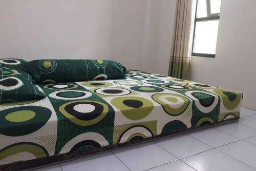 马格朗Anindya House的绿色和白色的被子的房间里一张床位