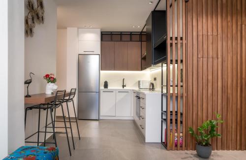 雅典Glyfada Gallery Apartment的厨房配有白色橱柜和不锈钢冰箱