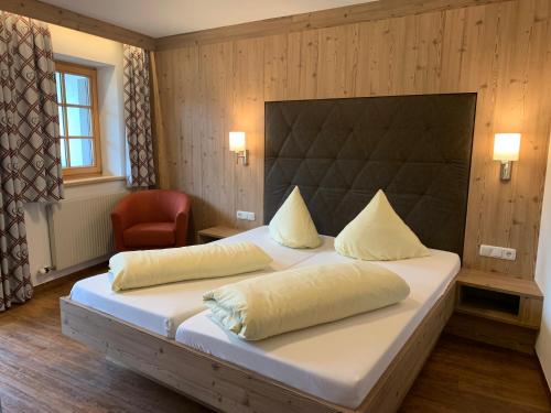 罗伊特哈斯特霍斯阿姆格哈本酒店的一间卧室配有一张大床和一把椅子