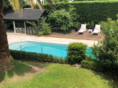 安格雷Appartement Ranavalo Pays Basque的享有带2把躺椅的游泳池的顶部景致