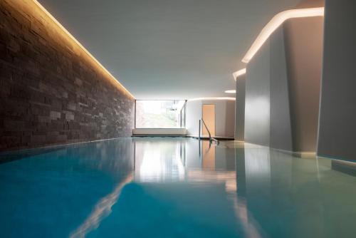 斯特拉斯堡Hotel Les Haras的砖墙房间的游泳池