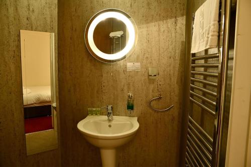 奈顿The Knighton Hotel的一间带水槽和镜子的浴室