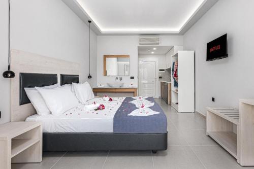 拉加纳斯Breeze Luxury Rooms的一间卧室配有一张带鲜花的大床