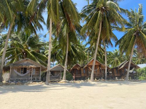 西塔努卡斯塔韦海滩别墅旅馆的棕榈树海滩上的一排小屋