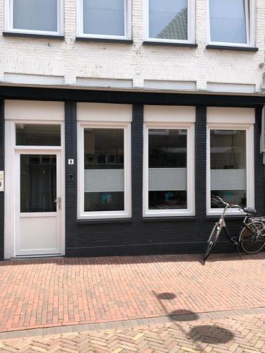 梅珀尔Centrum Meppel的一座有四扇窗户的建筑,外面有一辆自行车