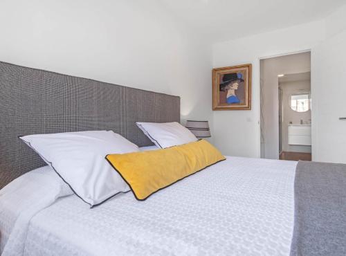 马德里Principe de Vergara I的卧室配有白色床和黄色枕头